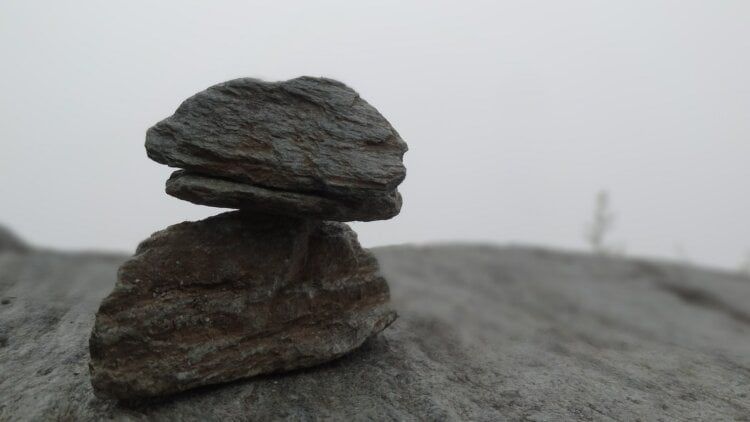 closeup photo of two gray stones on sand