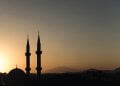 two mosque minarets under calm sky