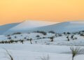 a snowy landscape with mountains in the distance
